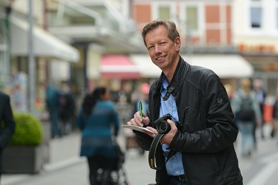 Ulf-Peter Busse der Bergedorfer Zeitung steht in einer Fußgängerzone