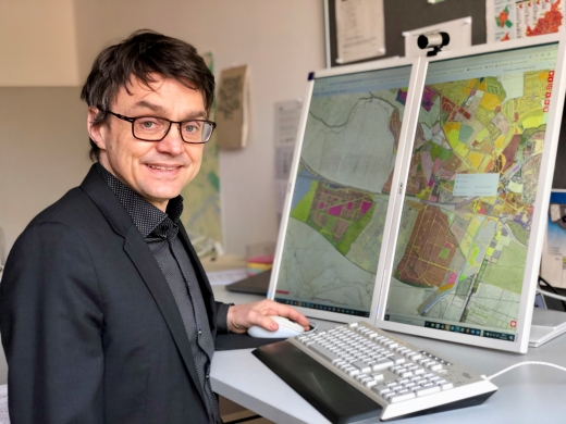Aretius Klosa des Bezirksamts Bergedorf steht an einem PC mit Plänen