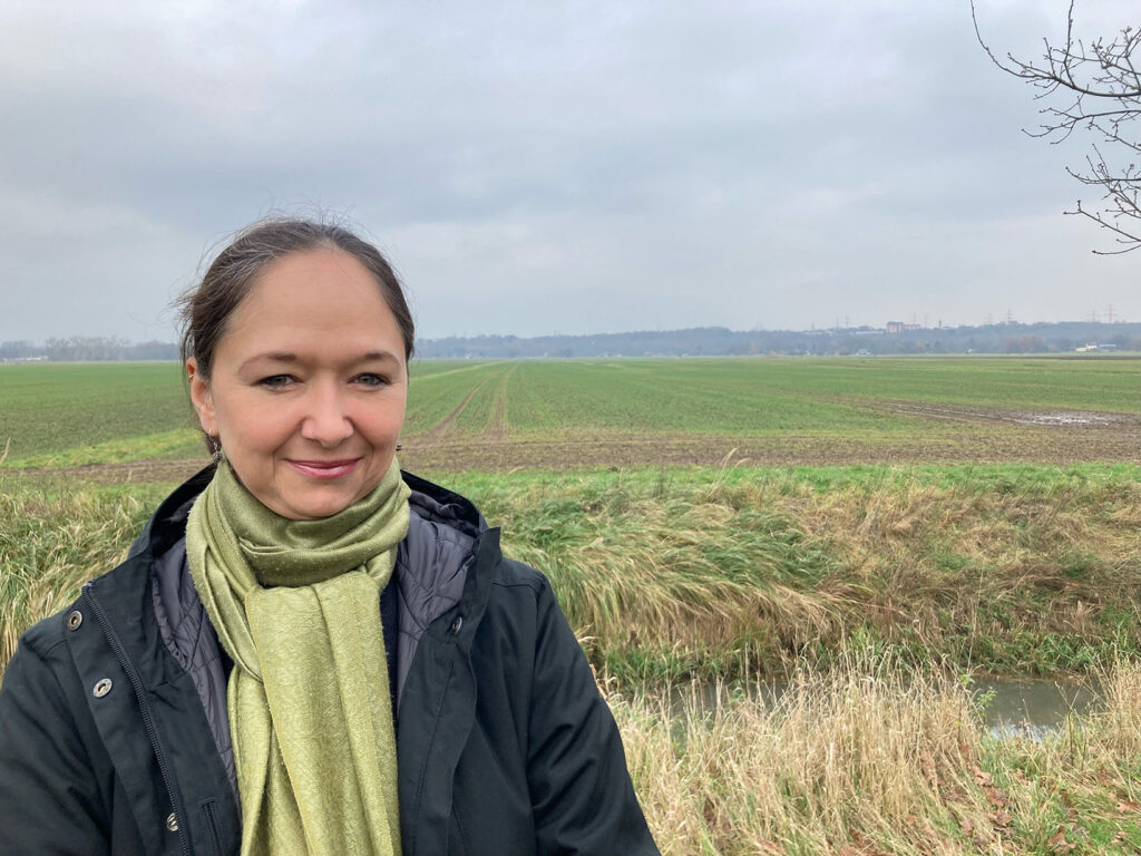 Jenny Jasberg der GRÜNEN Bergedorf steht vor einem Acker in Bergedorf