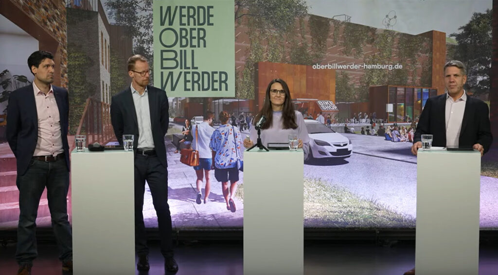Vier Personen stehen an Rednerpulten
