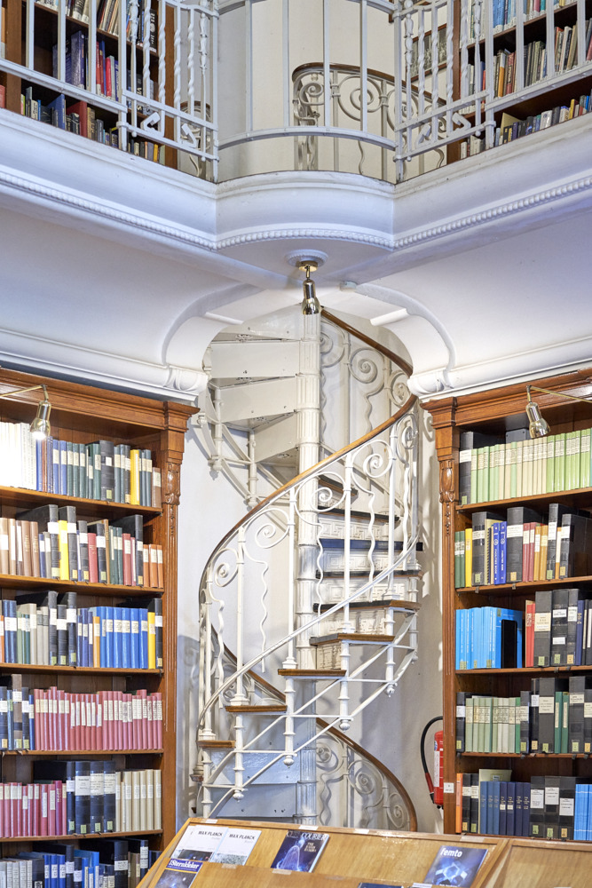Schmale Wendeltreppe umrahmt von Bücherregalen
