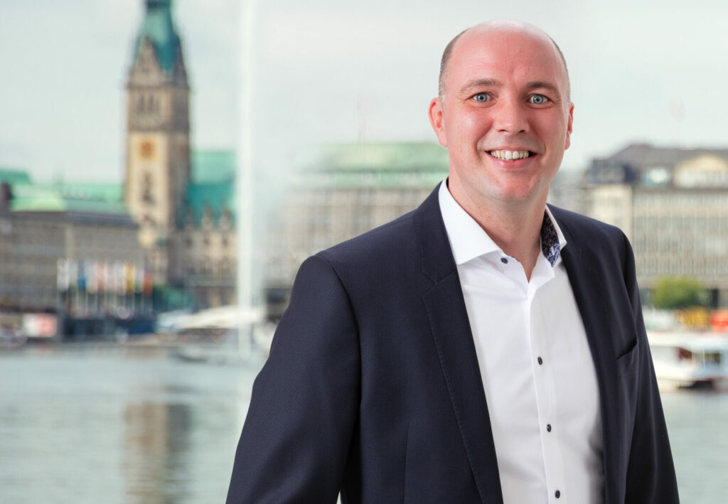 Portrait von Joel Schrage mit der Binnenalster im Hintergrund