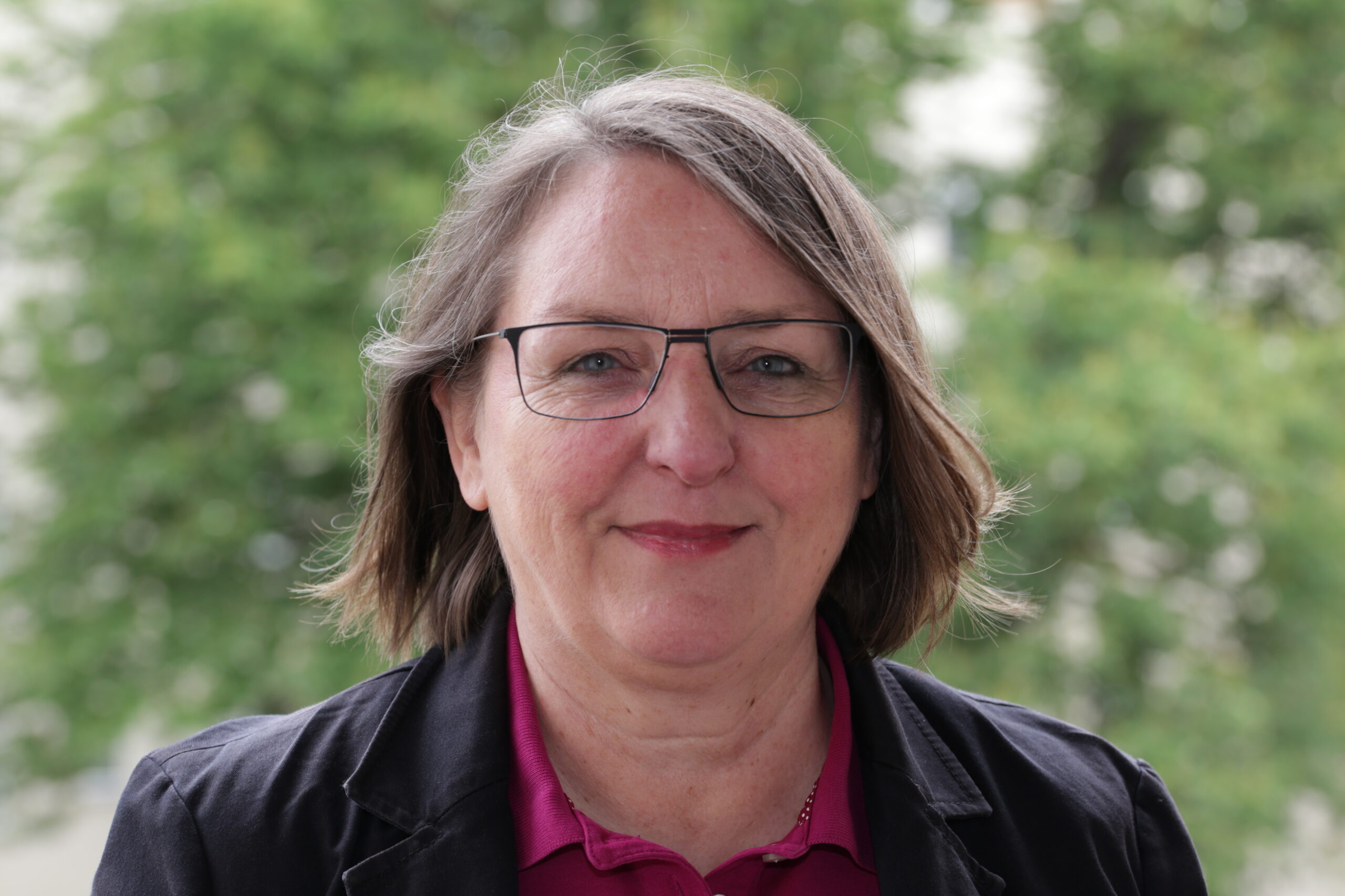Podcast-Gast Dr- Petra Potz vor Bäumen im Hintergrund