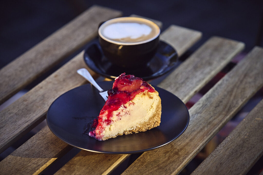 Stück Torte und Tasse Kaffee auf einem Holztisch