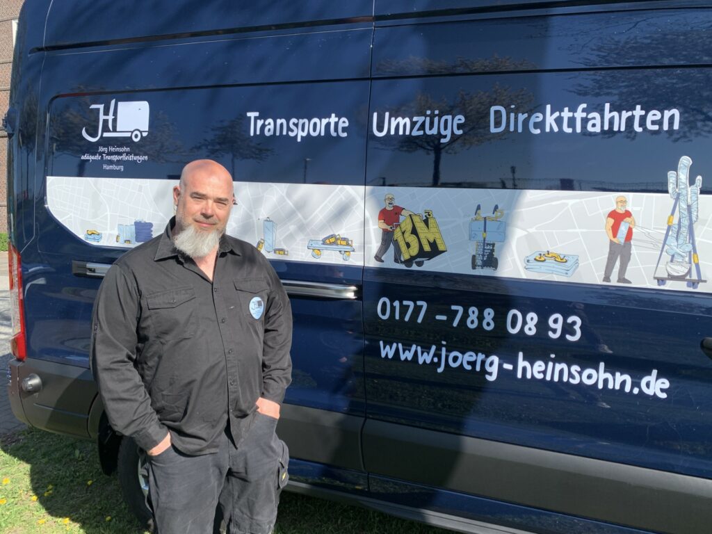 Mitmacher Jörg Heinsohn steht vor seinem Transporter