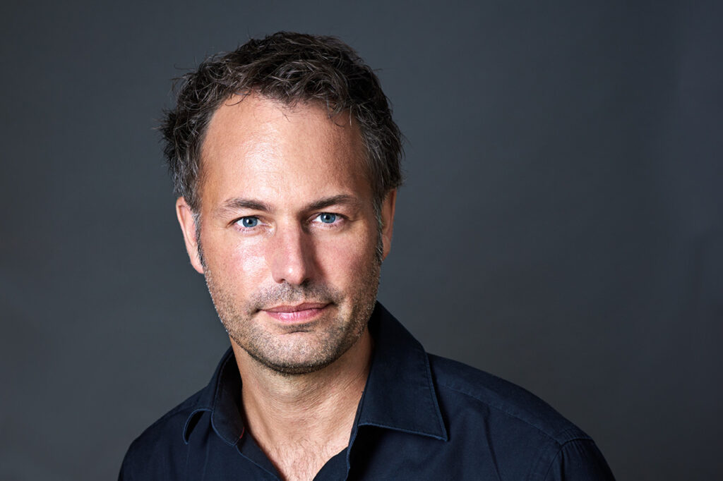 Portrait von Dan Schürch vor dunklem Hintergrund